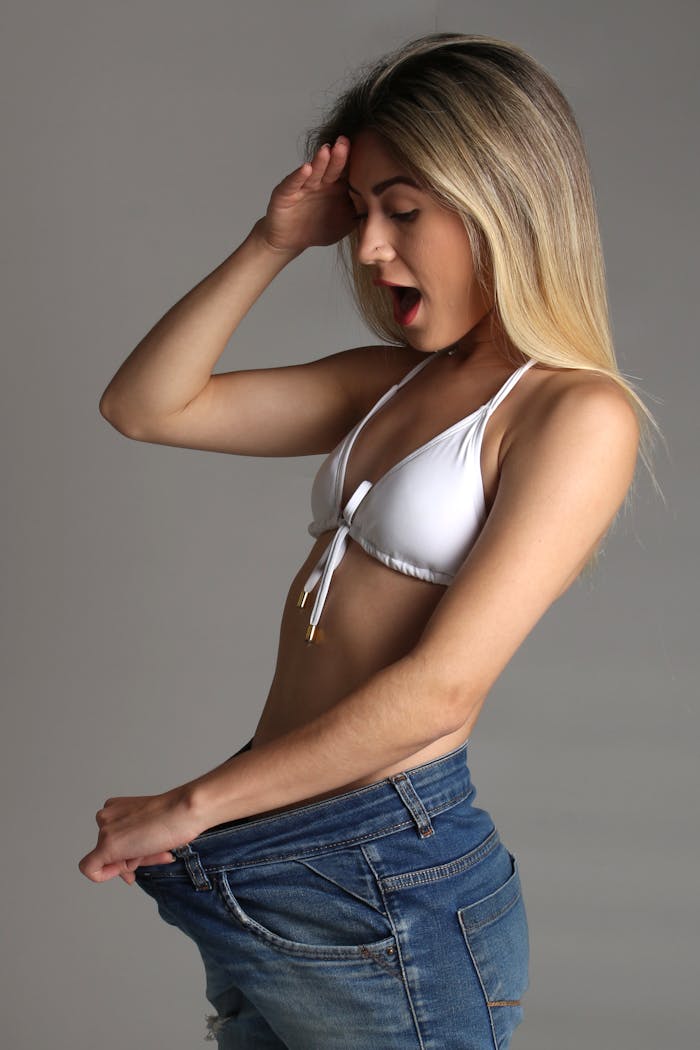 Woman in White Bikini Top and Denim Jeans